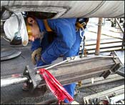Field service technician inspecting a hydraulic snubber